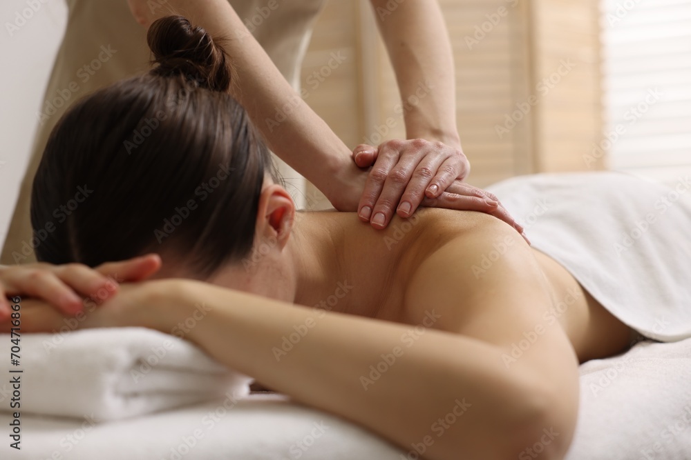 Woman receiving back massage on couch in spa salon Woman receiving back massage on couch in spa salon