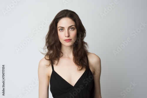 Portrait of a beautiful young woman in black dress. Studio shot.