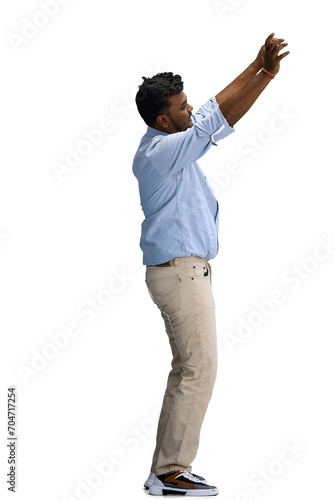 A man in a blue shirt, on a white background, in full height, waving his phone, in profile