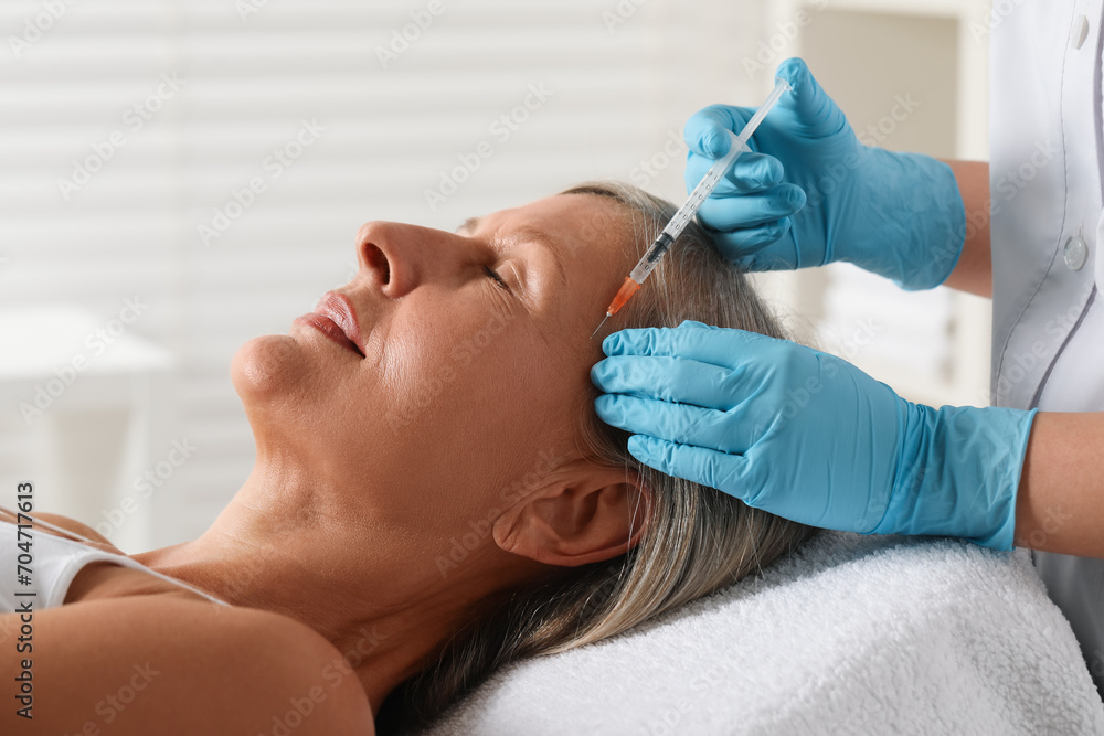 Doctor giving facial injection to senior woman in clinic, closeup. Cosmetic surgery Doctor giving facial injection to senior woman in clinic, closeup. Cosmetic surgery