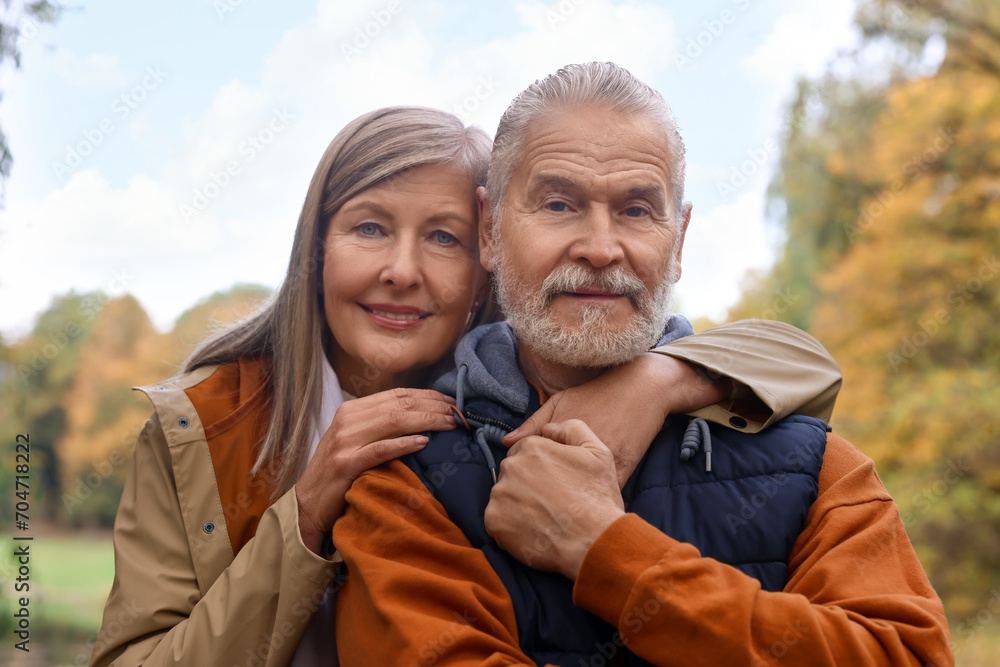Fototapeta premium Portrait of affectionate senior couple in autumn park