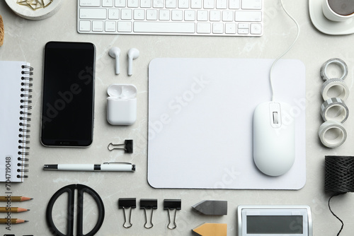 Flat lay composition with wired computer mouse and stationery on light grey table. Space for text photo