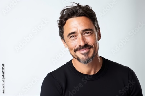 Portrait of a handsome man smiling at the camera on a gray background © Chacmool