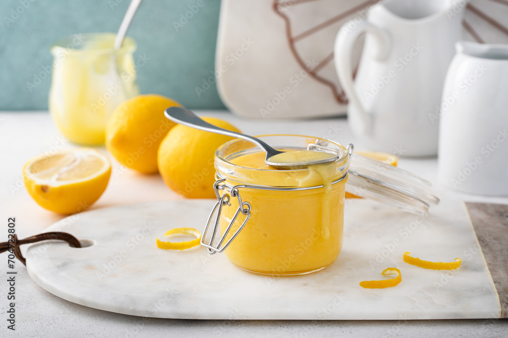 Lemon curd in a jar with fresh lemons, homemade dessert or topping idea Lemon curd in a jar with fresh lemons, homemade dessert or topping idea