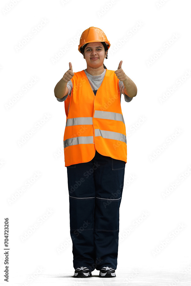 A female construction worker, on a white background, in full height, shows her thumbs up