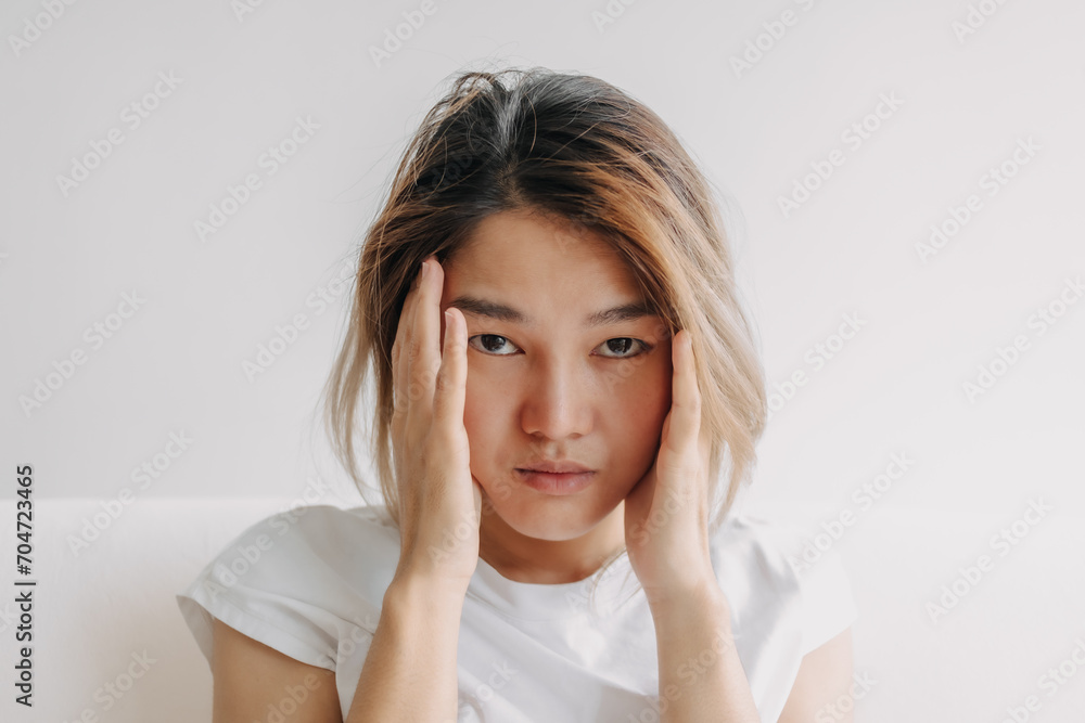 Close up headshot of headache hangover Asian woman with hand covering her head. Close up headshot of headache hangover Asian woman with hand covering her head.