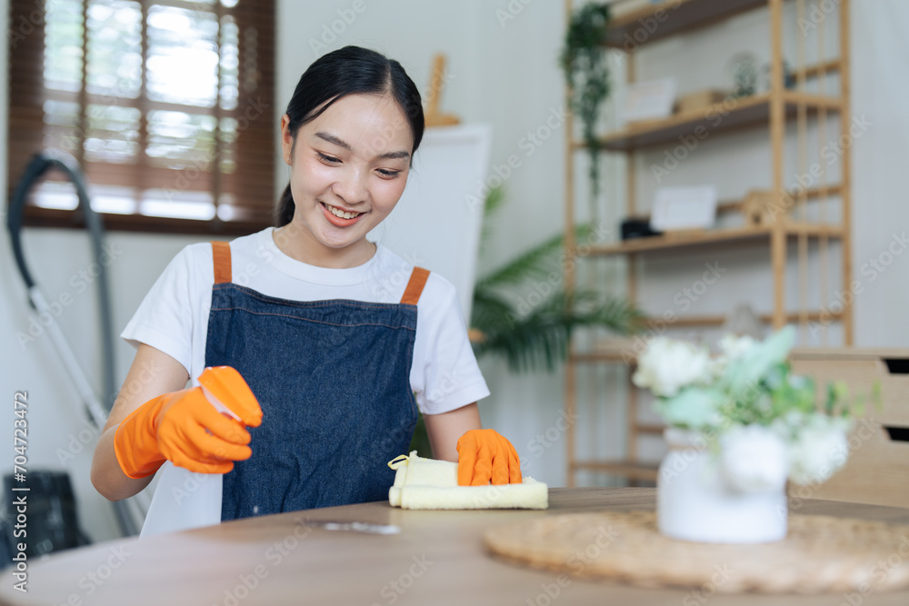 Young Woman happy to house and using rag and diffuser for cleaning table at home Young Woman happy to house and using rag and diffuser for cleaning table at home
