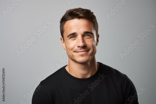 Handsome young man in black t-shirt on grey background