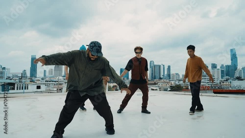 Professional hispanic break dancer practice B boy dance while multicultural friends at roof top. Young modern dancing group doing hip hop movement. Style,fashion,action. Outdoor sport 2024. hiphop.