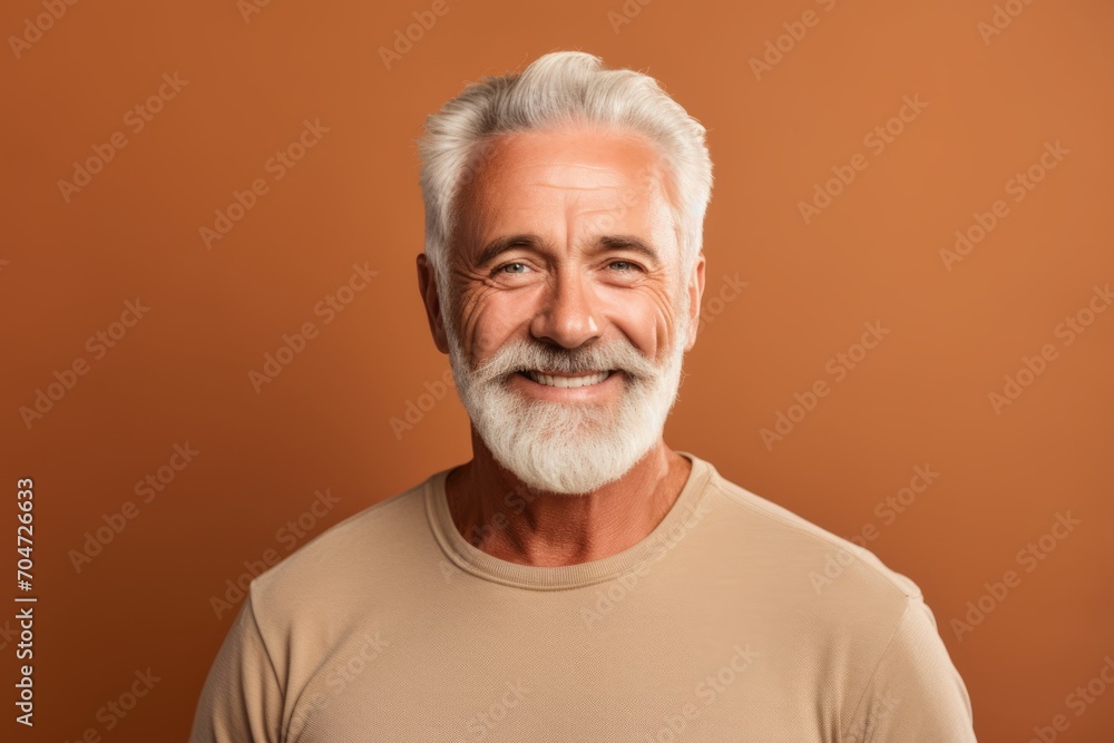 smiling senior man with grey hair looking at camera isolated on brown smiling senior man with grey hair looking at camera isolated on brown