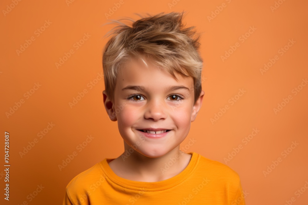 Portrait of a cute little boy with blond hair on a orange background Portrait of a cute little boy with blond hair on a orange background