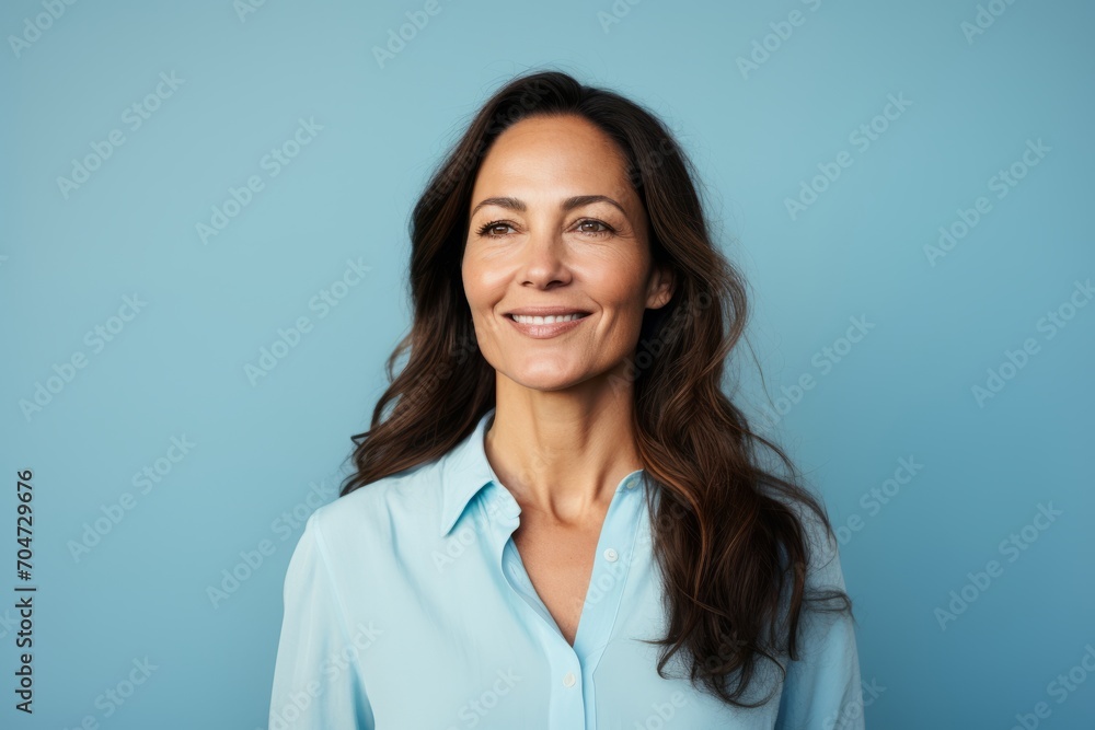 Portrait of a smiling businesswoman looking at camera over blue background Portrait of a smiling businesswoman looking at camera over blue background
