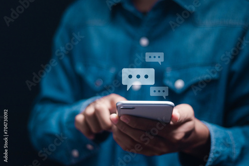 Social media marketing technology. Man typing on mobile smart phone chatting conversation in chat box icons pop up. Live Chat Chatting on application.