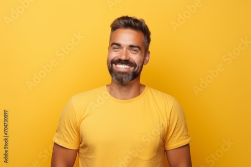 happy man in yellow t-shirt looking at camera over yellow background