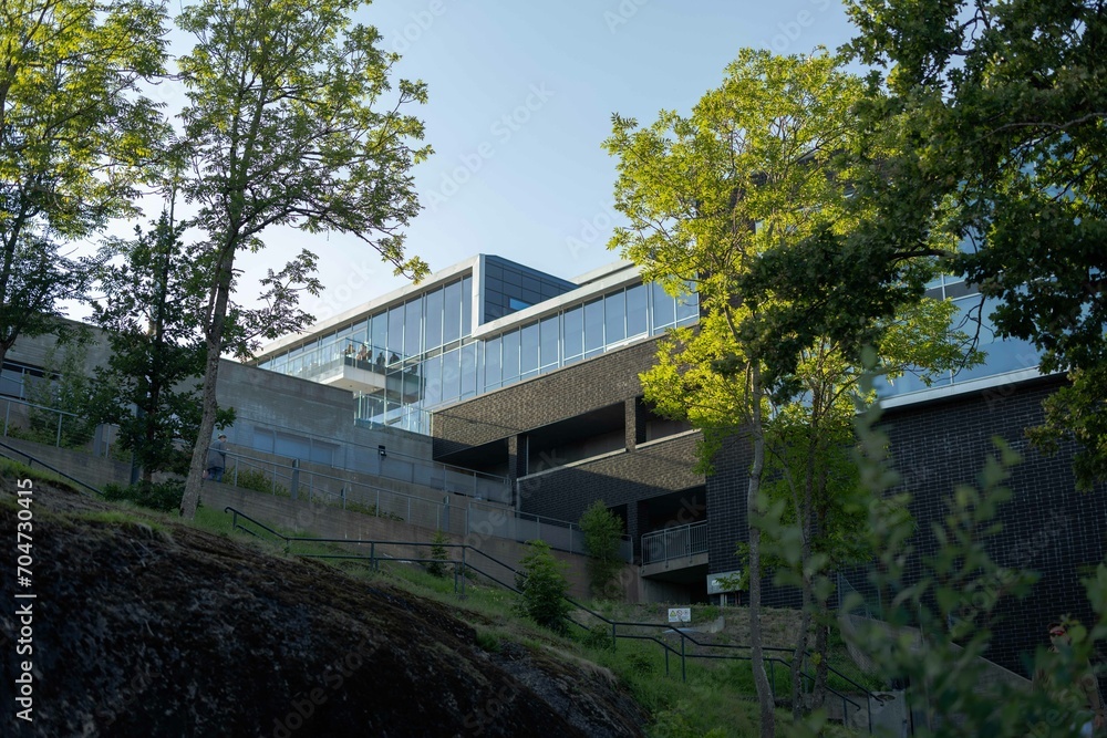 Modern glass building with green scenery surrounding Modern glass building with green scenery surrounding