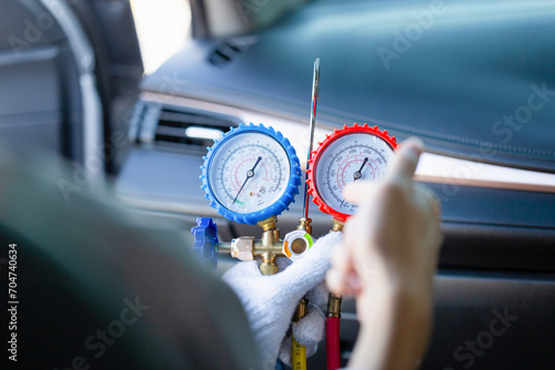 Technician check car air conditioning system refrigerant recharge, Repairman holding monitor tool to check and fixed car air conditioner system, Air Conditioning Repair. photo