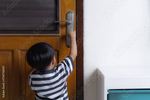 curious toddler kids trying hold the key to locking the wooden door
