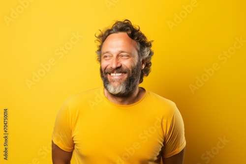 Middle age man with a yellow t-shirt on a yellow background © Inigo