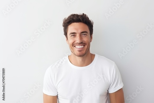 Handsome young man in white t-shirt smiling at camera
