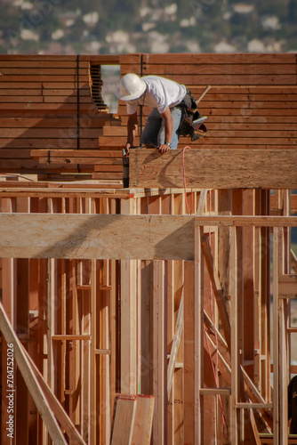 Constrction worker on wood framing with white hard hart