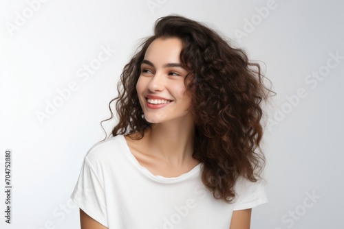 Beautiful smiling young woman with long curly hair on a white background