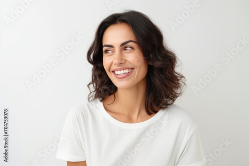 Portrait of a happy young woman smiling and looking up over white background