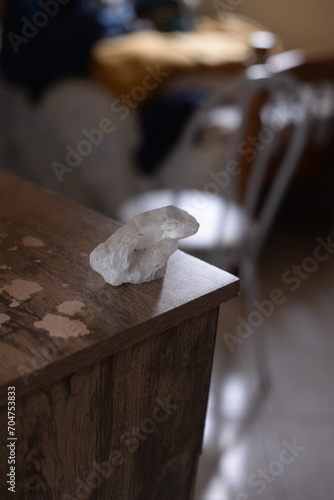 Pedra quartzo branco em cima da mesa de madeira no quarto a luz do dia photo