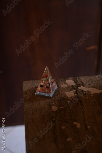 Pirâmide como peso de papel translucida em cima da mesa de madeira