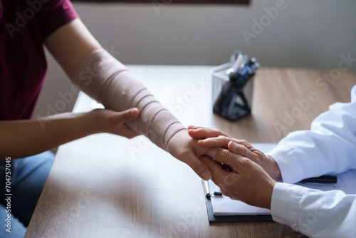 Doctor is examining the arm of a female patient who has been in an accident.