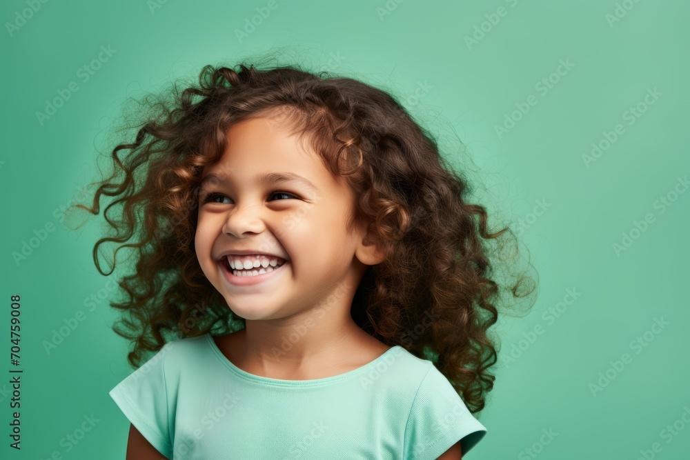 Portrait of a smiling little girl with curly hair on a green background Portrait of a smiling little girl with curly hair on a green background