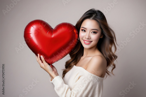 celebration for Valentine's Day with beautiful young woman holds a red heart in her hands. © Dwi
