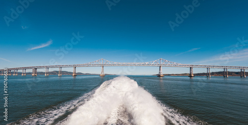 Tableau sur toile Riding on a speed boat under a bridge with a large wake
