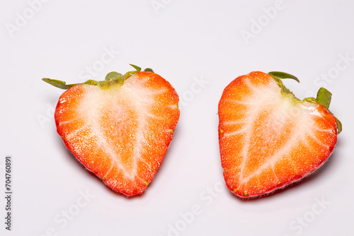 Strawberries cut in half on a white background