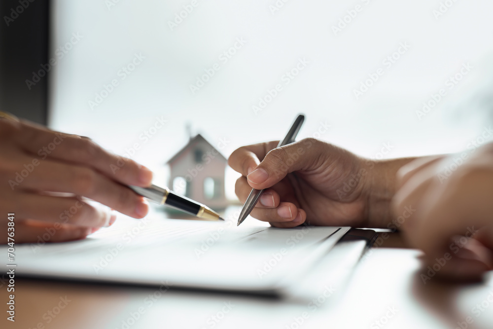 Professional real estate agent guiding and explaining the document process to the customer Professional real estate agent guiding and explaining the document process to the customer