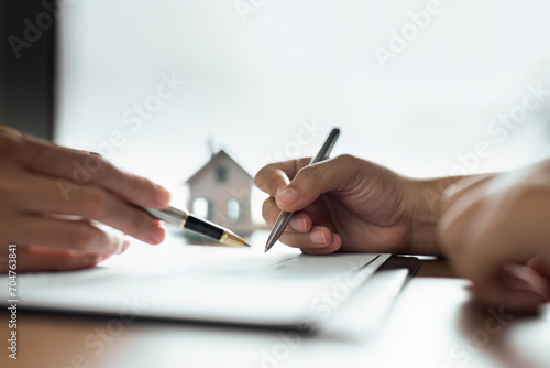 Professional real estate agent guiding and explaining the document process to the customer photo