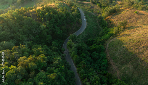 Aerial view of road dark green forest Natural landscape and elevated traffic roads Adventure travel and transportation ideas for the environment 
