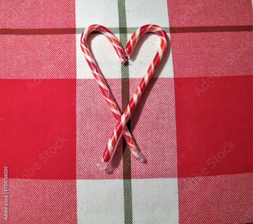 Candy cane hearts on red and white laid background