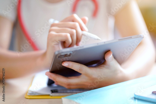 Closeup and crop hands of medical young female student in casual cloth make a short note on tablet. Education concept