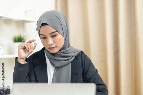 Young muslim beautiful businesswoman wear hijab working in modern business office use laptop computer. Islamic female freelance designer Thinking seriously about work.