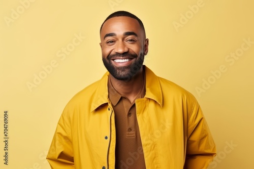 Portrait of happy african american man in yellow shirt on yellow background © Inigo