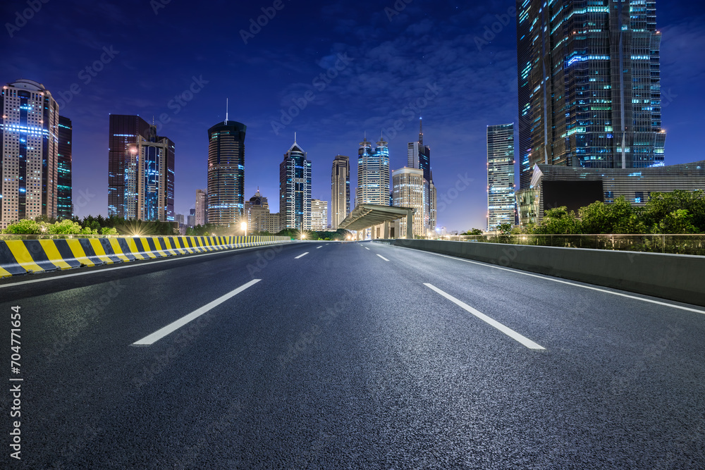 Asphalt road and modern city commercial buildings at night in Shanghai