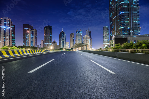 Asphalt road and modern city commercial buildings at night in Shanghai