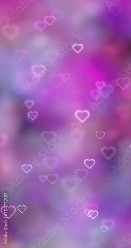Blurred soft pink bokeh with glowing heart symbols loop motion background. Valentine's day holidays vertical copy space greeting card.