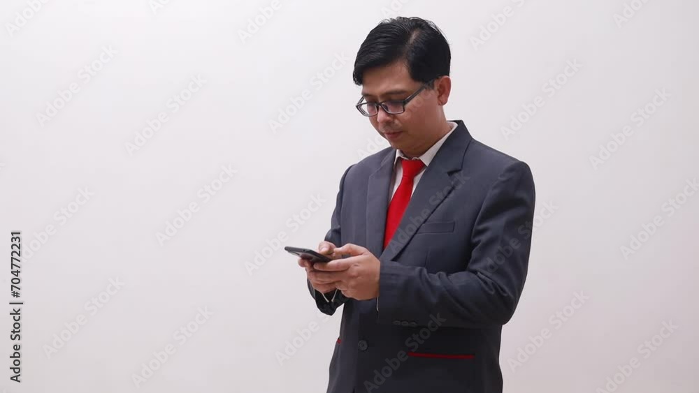 Asian businessman standing while talking on the phone Asian businessman standing while talking on the phone
