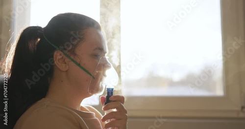Sick Woman Inhaling Mist From Nebulizer Mask - Treatment For Respiratory Diseases. - side view, close up shot photo