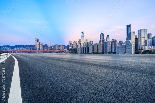 Asphalt road and urban skyline with modern buildings at dusk in Chongqing