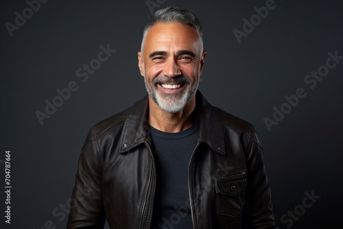 Portrait of a handsome middle-aged man wearing a black leather jacket.