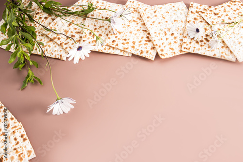 Festive background for the Jewish Passover holiday. Traditional retual matza bread and white delicate spring flowers. A copy space. frame, border. photo