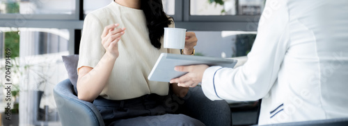Salesperson presents a product, service, travel, savings, finance, investment or life insurance to a businesswoman using a tablet device