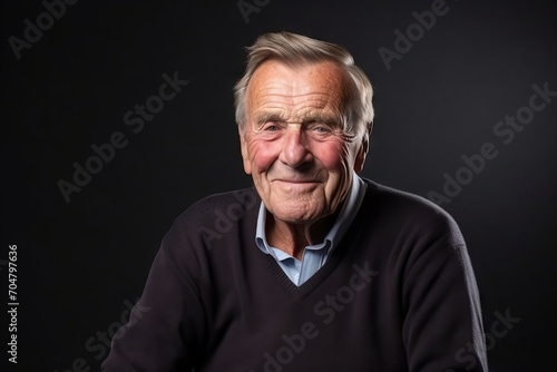 Portrait of an elderly man on a dark background. Studio shot.